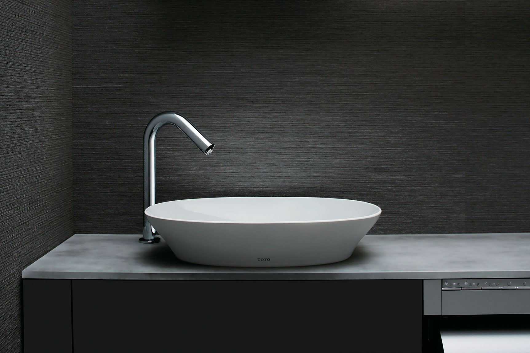 A TOTO KIWAMI Oval Vessel Lavatory displayed in a modern bathroom on a smooth slate countertop.