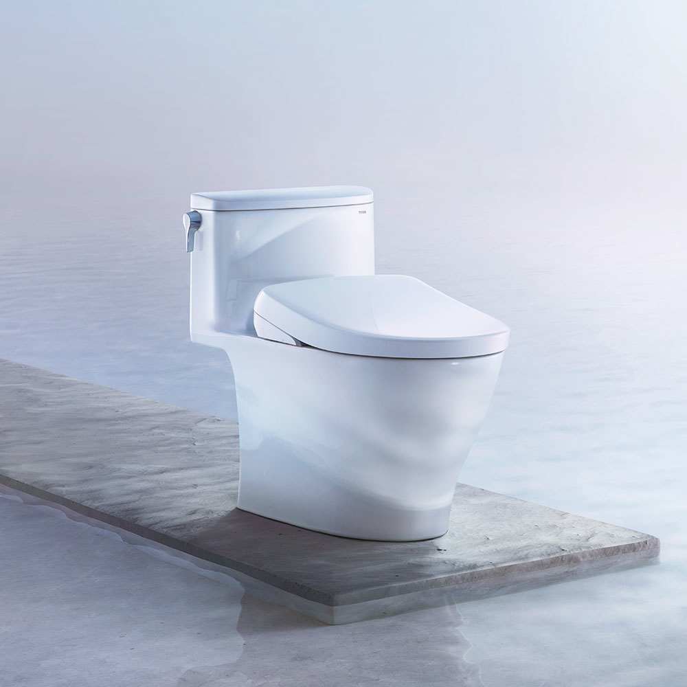 A TOTO WASHLET S7 bidet seat artistically displayed on a platform over clear blue water.