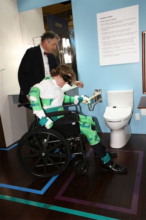 A design professional participates in a physical impairment simulation to better understand the importance of universal bathroom design