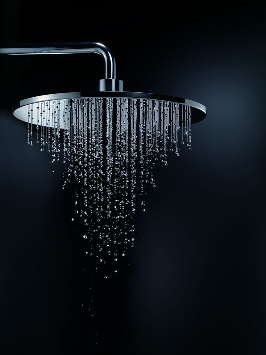 Chrome rainfall shower head with water droplets against a dark background, showcasing a luxurious and modern design